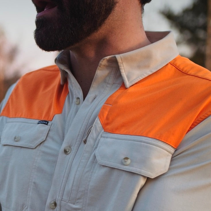 closeup of man wearing blaze orange shoulder patch shirt